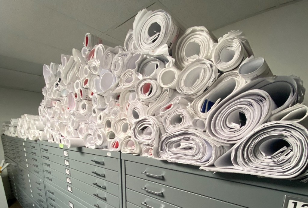 Rolled construction drawing sets on a table